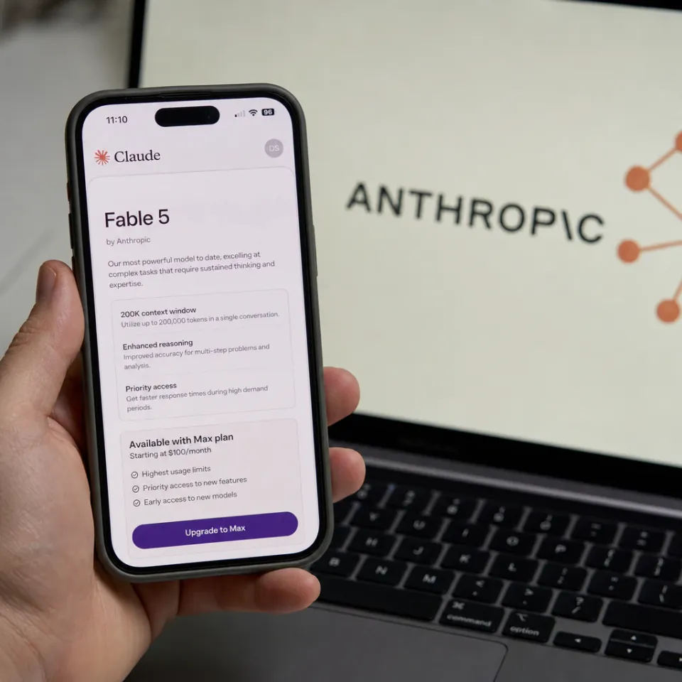 Smartphone mit der Claude-App von Anthropic, auf dem Bildschirm ist das Modell Fable 5 zu sehen, im unscharfen Hintergrund ein Laptop mit dem Anthropic-Logo